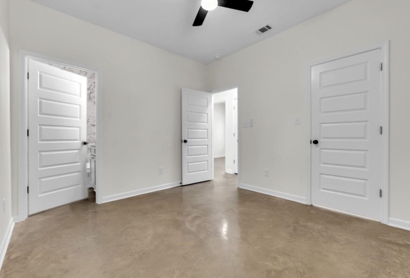 Spacious interior room featuring light-toned flooring and white walls