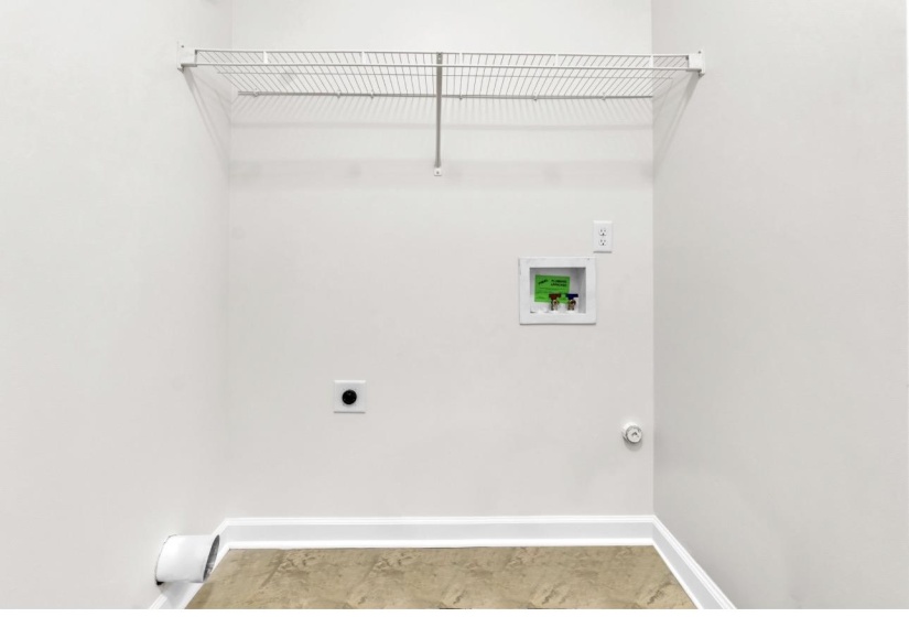 Dedicated laundry area featuring a wire storage shelf, utility hookups, and neutral-toned flooring