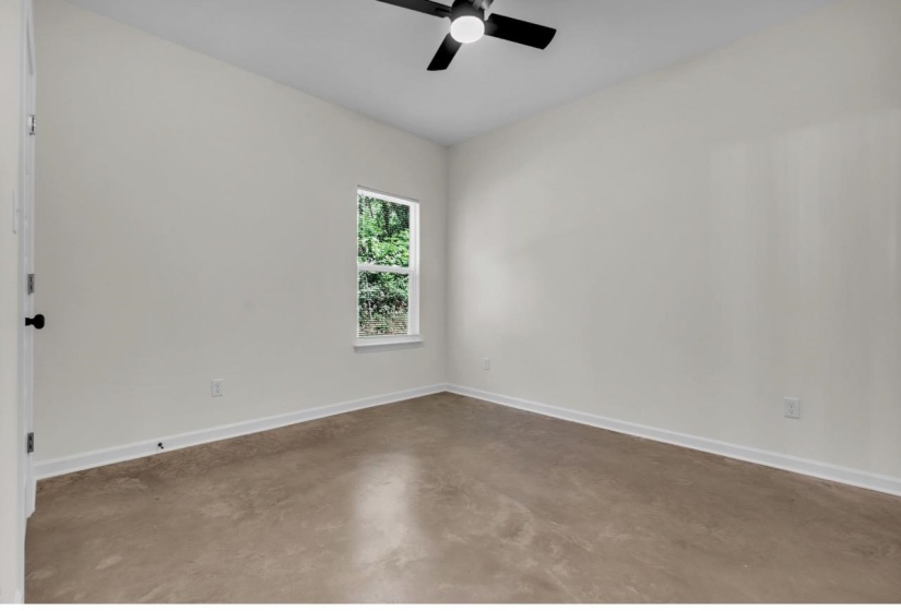 Room featuring light-toned walls, a single window, and a ceiling fan with integrated lighting
