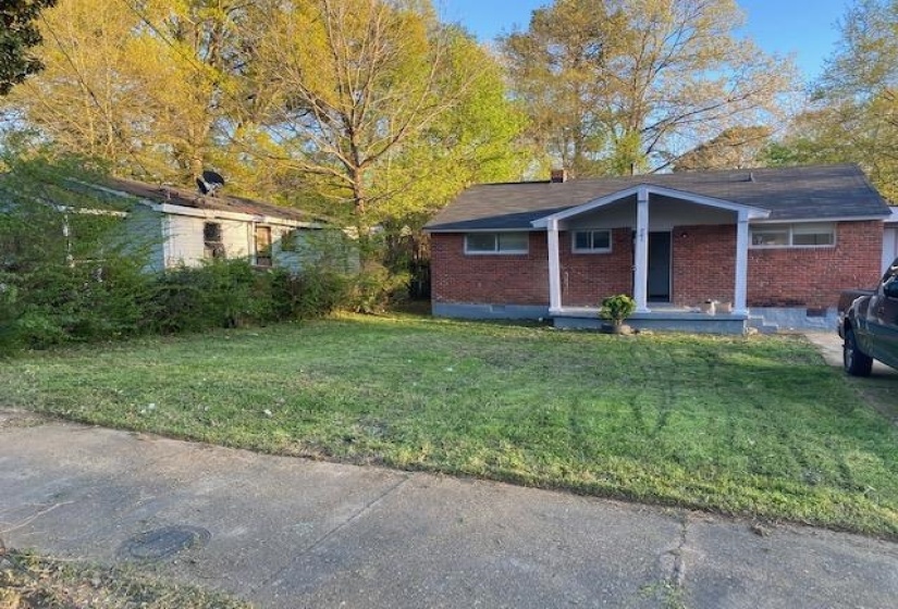 View of home's exterior featuring crawl space, brick siding, covered porch, and a yard