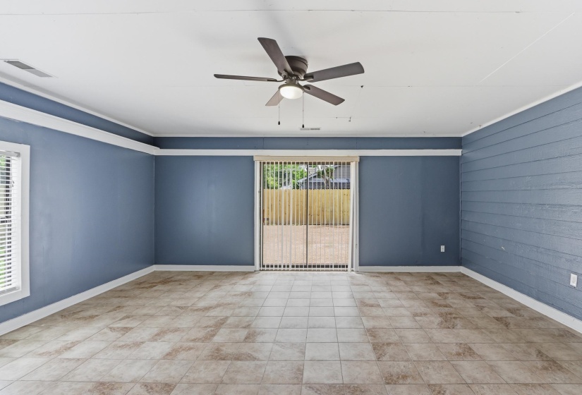 Expansive room featuring blue walls, white trim, and a ceiling fan