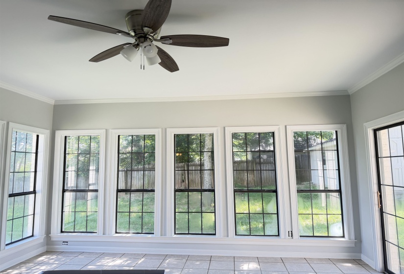 Sunroom featuring a full wall of windows and a ceiling fan with integrated lighting