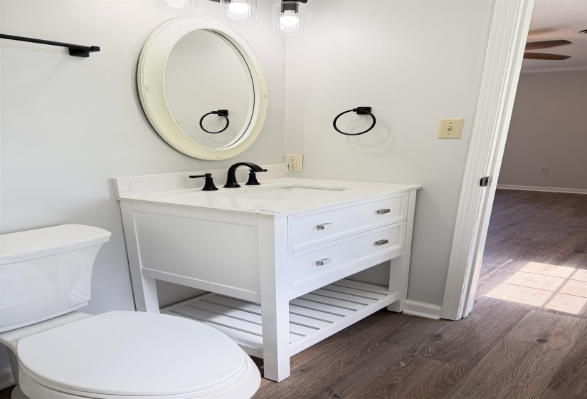 Bathroom featuring a white vanity with two drawers, an oval mirror, and a white toilet