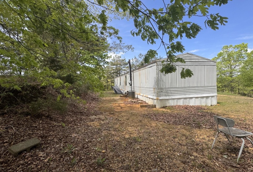 Single-story structure with corrugated siding and a sloped roofline, set on a foundation skirting