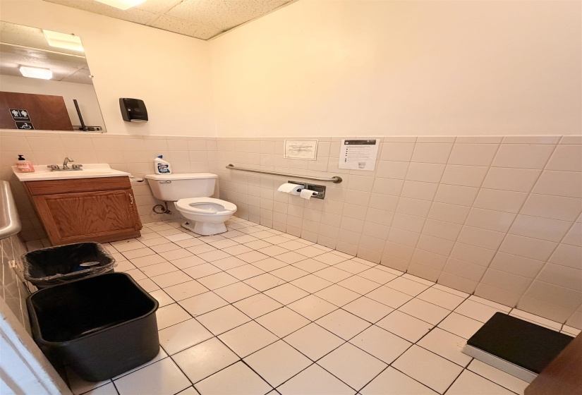 Bathroom featuring vanity, a wainscoted wall, tile walls, and a paneled ceiling