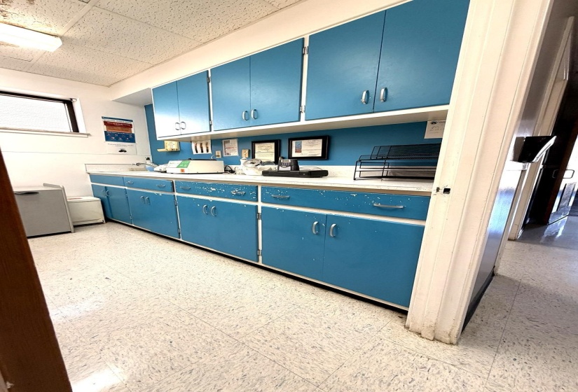 featuring blue cabinets, light countertops, and a drop ceiling