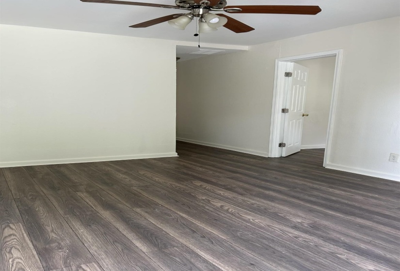 Spare room featuring dark wood-type flooring and ceiling fan