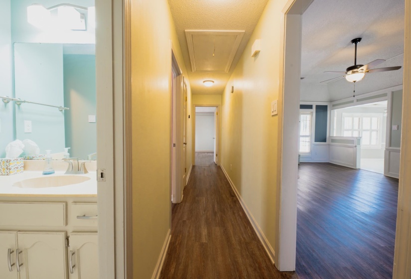 Hallway featuring wood-finish flooring, recessed lighting, and an attic access panel