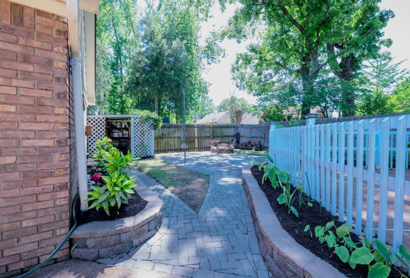 Patio area featuring brick pavers and stone retaining walls
