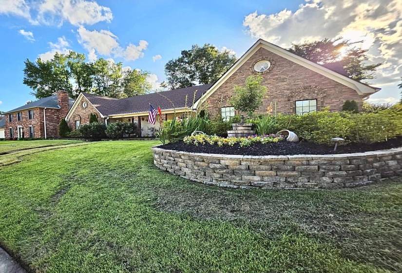 Brick facade residence featuring a prominent gabled roofline and an arched window