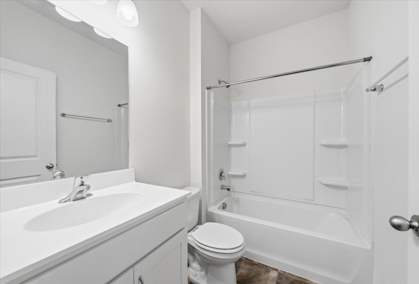Bathroom featuring a white vanity with integrated sink, chrome faucet, wall-mounted mirror, and a three-bulb vanity light fixture