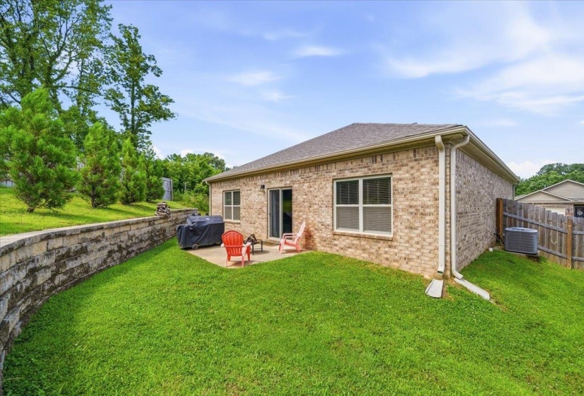 Rear exterior featuring a brick facade and a concrete patio