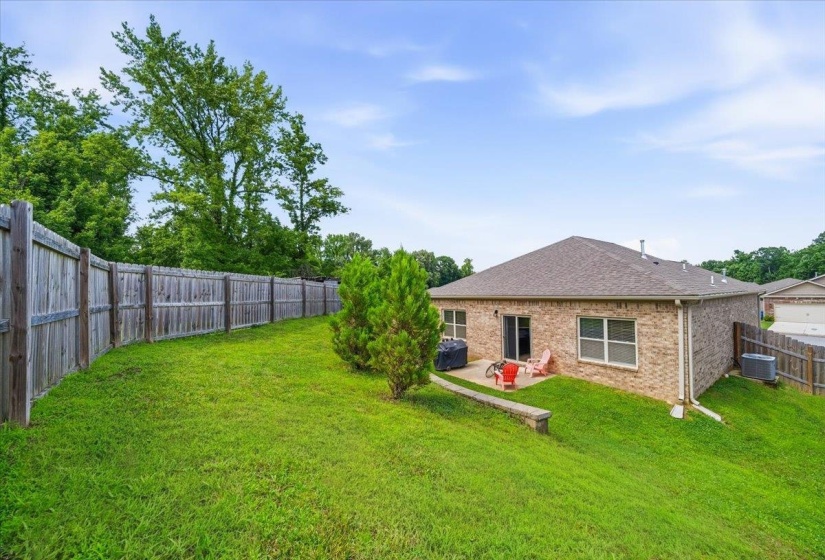 Expansive lawn area featuring a full privacy fence