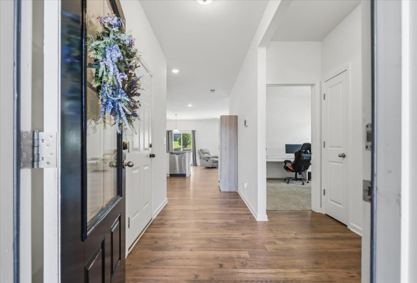Entryway featuring wood-finish flooring, white walls, and recessed lighting