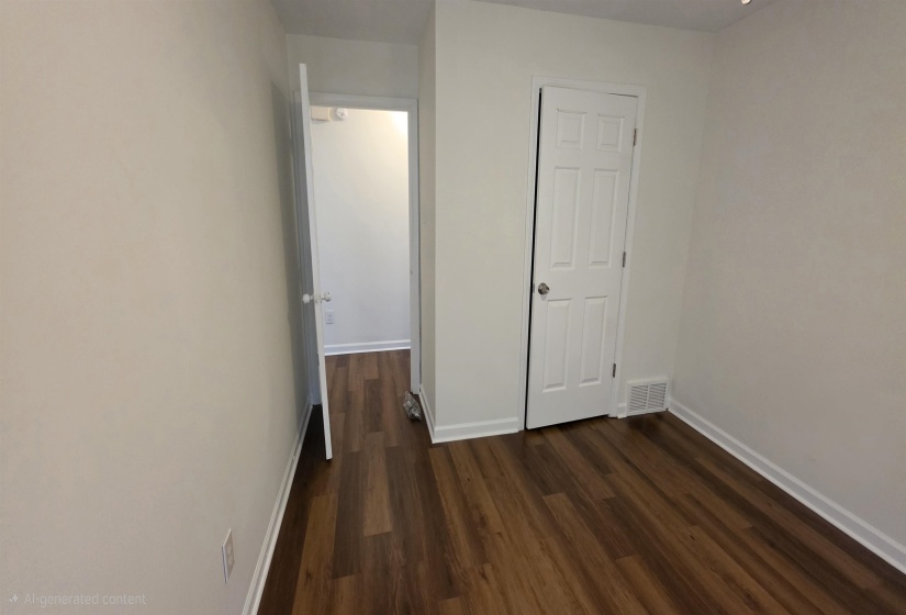 Interior room featuring wood-finish flooring and white baseboards