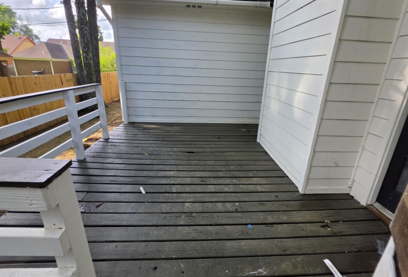 Outdoor deck area with horizontal plank flooring and white railing