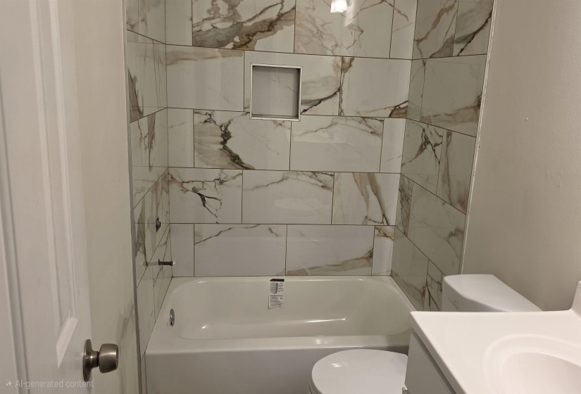 Bathroom featuring a white bathtub, white toilet, and a vanity with an integrated white sink