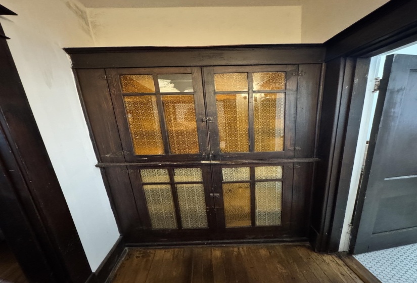 Built-in dark wood cabinetry with textured glass panels