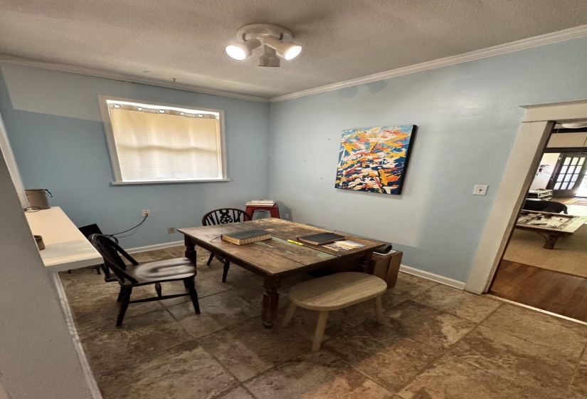 Bright room featuring a window with horizontal blinds, track lighting, and square floor tiles