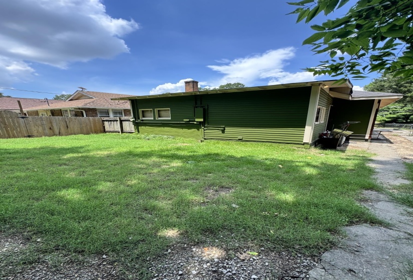 Expansive green lawn with a wood fence and a concrete path