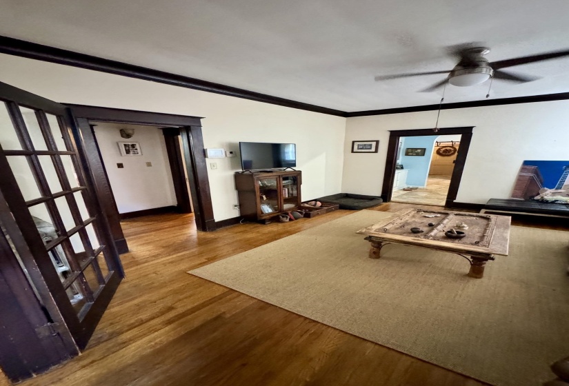 Hardwood flooring throughout, featuring dark wood trim and crown molding