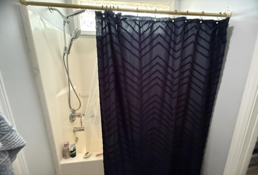 Shower-over-tub combination with a wall-mounted shower head and a handheld shower head