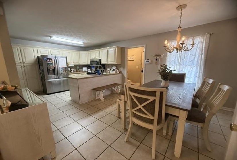 Kitchen with tile flooring and cream cabinetry