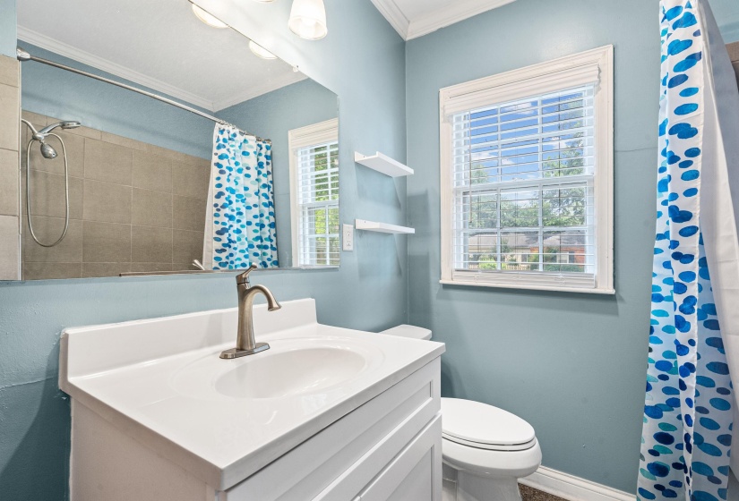 Shared full bath features tall vanity and shower with a jacuzzi tub.