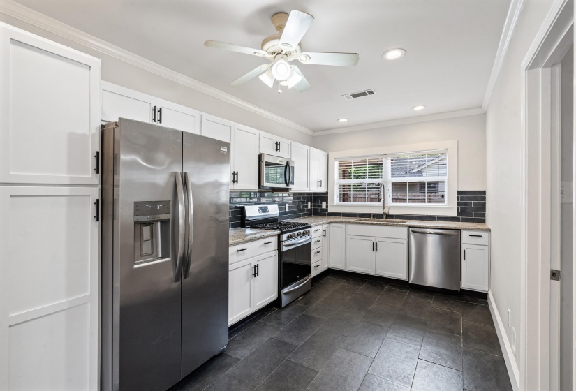 Completely renovated kitchen features new cabinets, granite counter tops, SS appliances, large deep sink, smooth ceilings, and recessed lights.