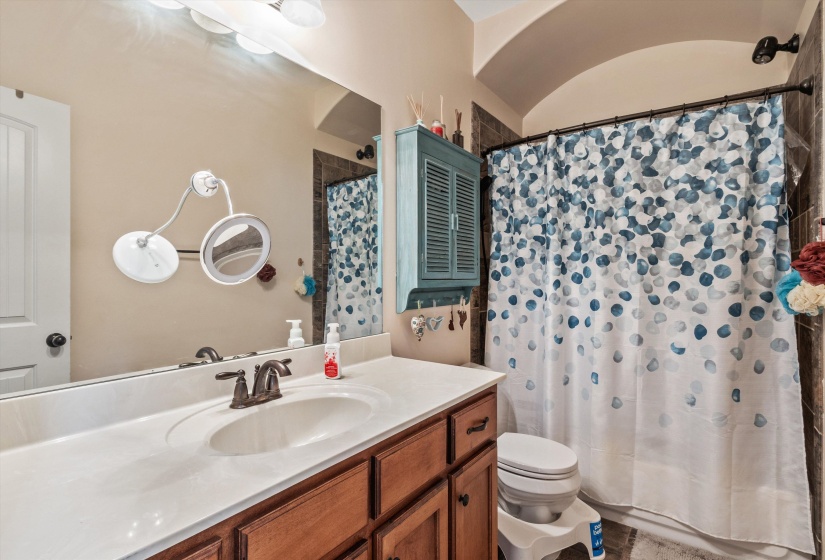 Bathroom vanity featuring a single basin sink, bronze-finish faucet, and white countertop