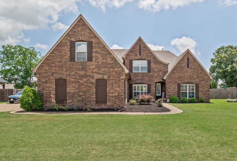 Brick exterior residence featuring multiple gables and dormers