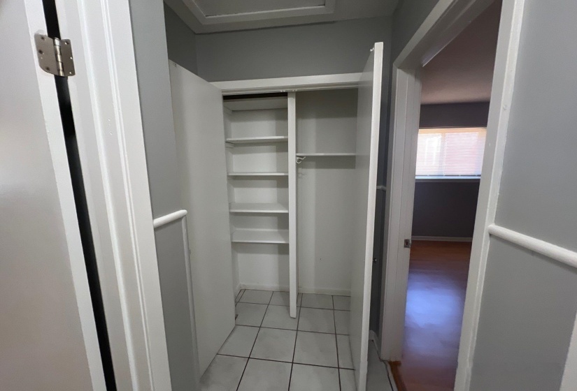 Built-in closet with white shelving and hanging rod