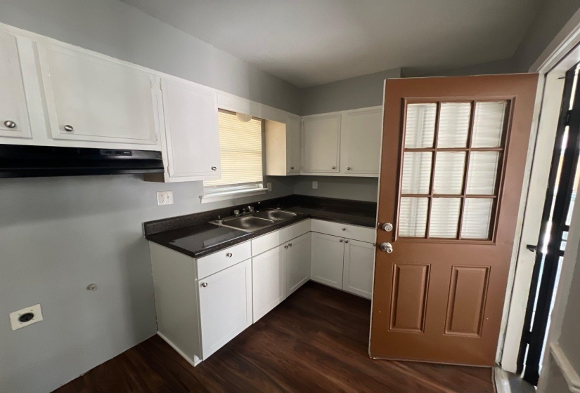 Kitchen featuring white cabinetry, dark countertops, and wood-finish flooring
