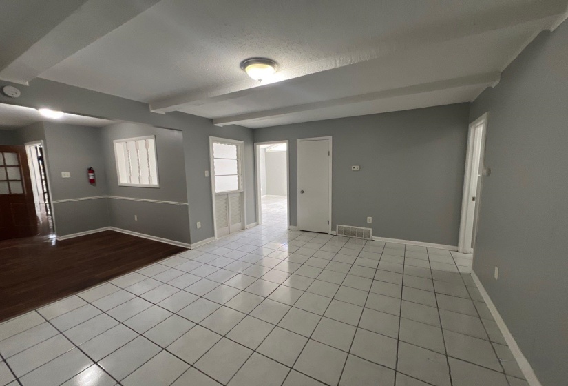 Spacious interior featuring a combination of white tile flooring and wood-finish flooring