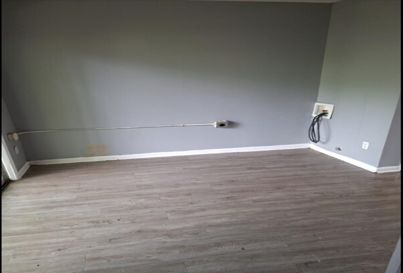 Utility area featuring wood-finish flooring, light gray walls, and white baseboards