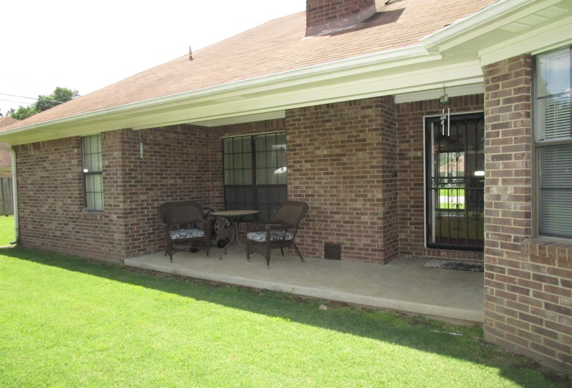 Covered patio featuring a concrete slab and brick exterior