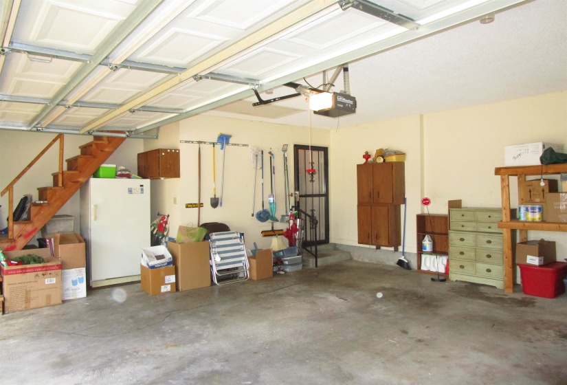 Two-car garage featuring a concrete floor, painted walls, and a finished ceiling Notice walk up steps to attic Heated & cooled bonus room/storage 18x9
