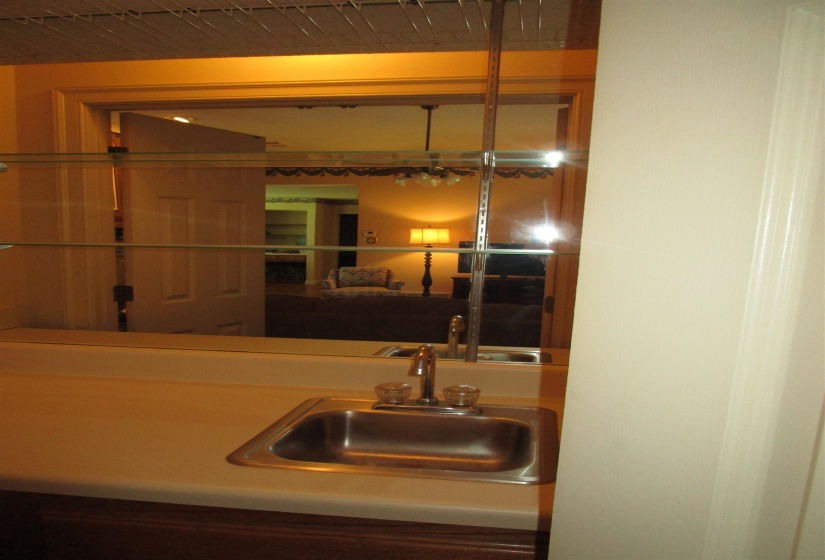 Located in great room wet bar with mirrored wall, shelves, and storage cabinets
