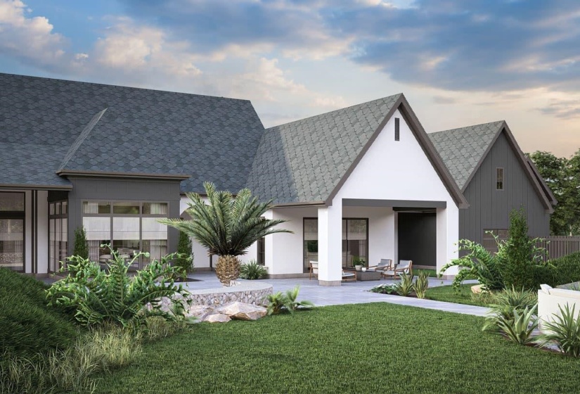 Rear exterior featuring multiple gable roofs with gray shingles, a covered patio with concrete flooring, a manicured lawn, and surrounding mature landscaping with a palm tree