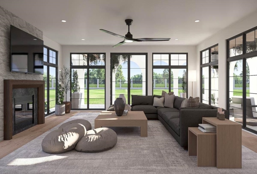Spacious living area featuring light wood-finish flooring, a stone-accented fireplace with wood surround, and a ceiling fan
