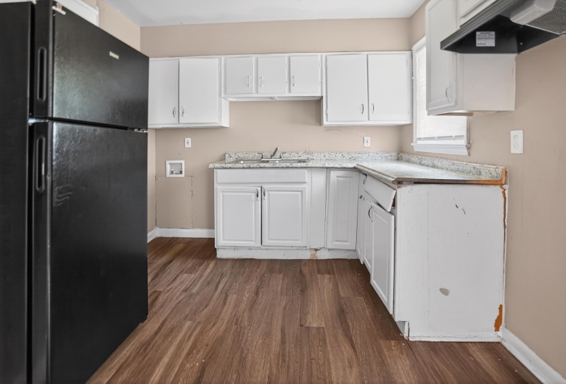 Kitchen featuring wood-finish flooring, white cabinetry, and granite-look countertops