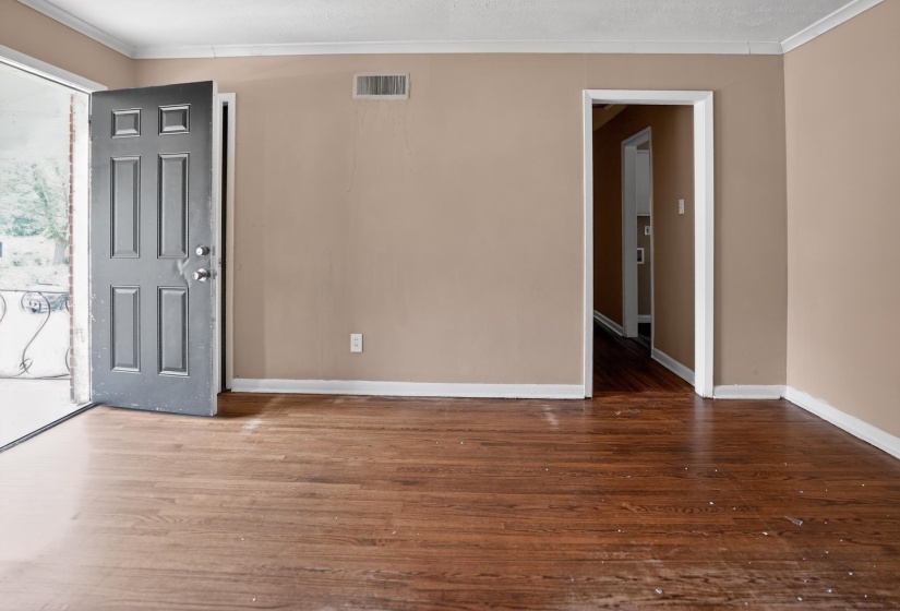 Spacious room featuring wood-finish flooring, neutral-toned walls, and white baseboards