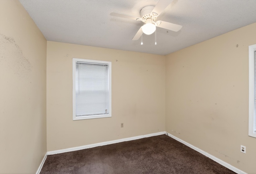 Room featuring brown carpeting, a white ceiling fan with integrated lighting, and neutral-toned walls