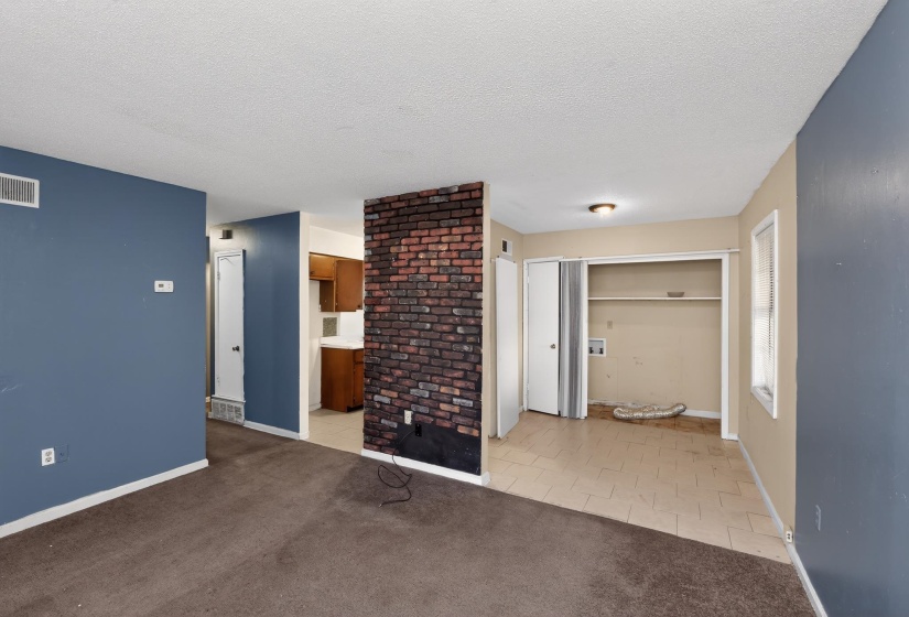 Open living area featuring a prominent brick accent wall