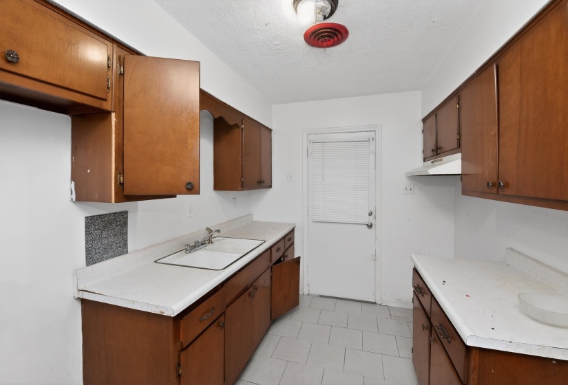 Kitchen featuring wood-finish cabinetry and white countertops
