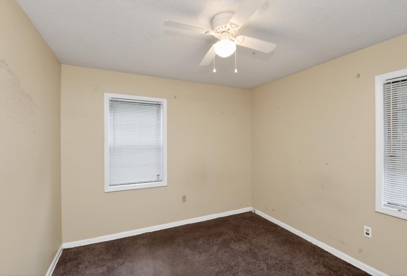 Interior room featuring neutral wall paint, white trim, and dark brown carpeting