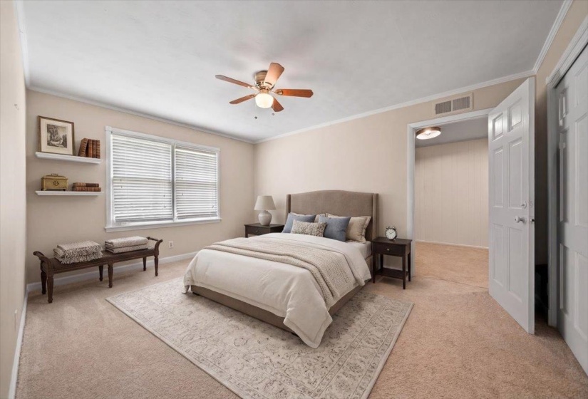 Virtually staged upstairs bedroom; Carpeted bedroom featuring a ceiling fan, crown molding, and a window with blinds