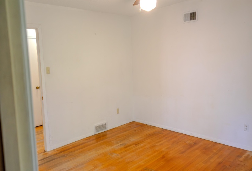 Room featuring wood-finish flooring, white walls, and white baseboards