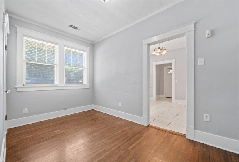 Room featuring wood-finish flooring, light gray walls, and white trim
