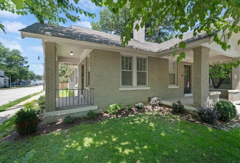 Brick exterior home featuring a covered front porch with column supports and a decorative metal railing